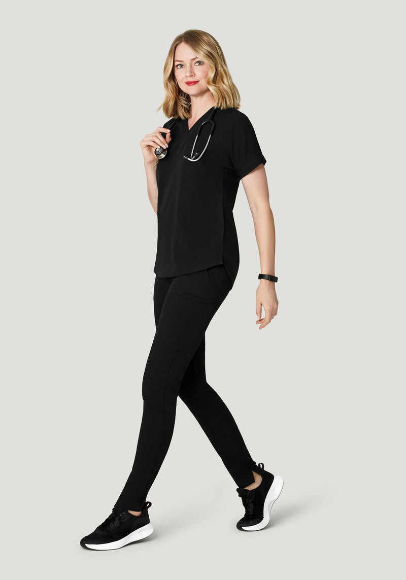 Woman wearing black leggings, black button-down shirt and mauve